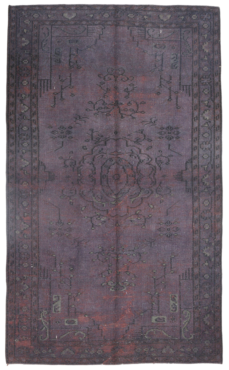 Vintage purple rug with intricate patterns on a plain background