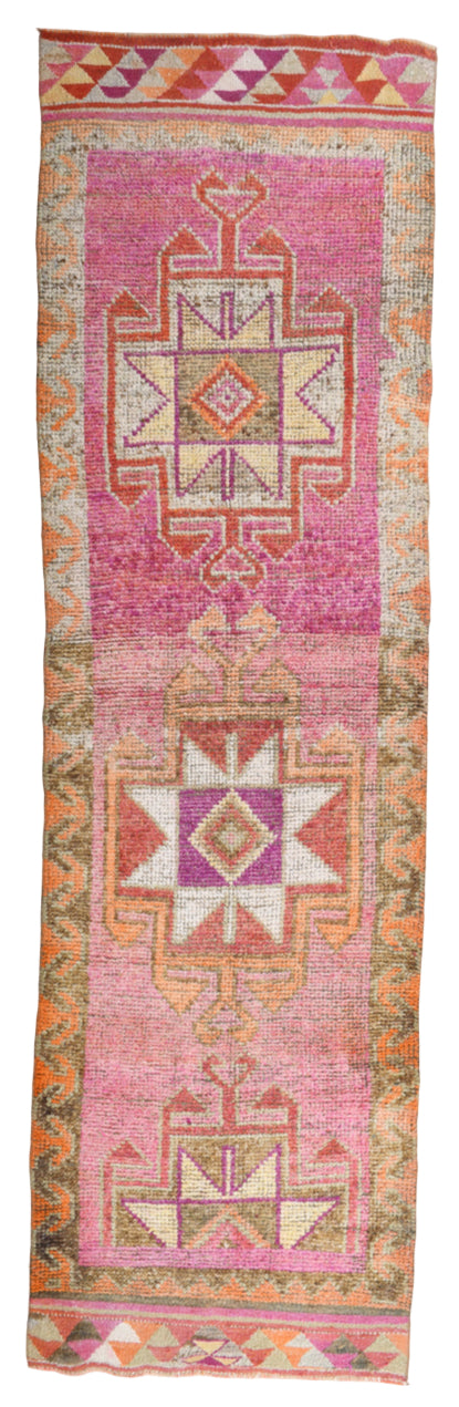 Decorative pink and multicolor rug with geometric patterns on a white background