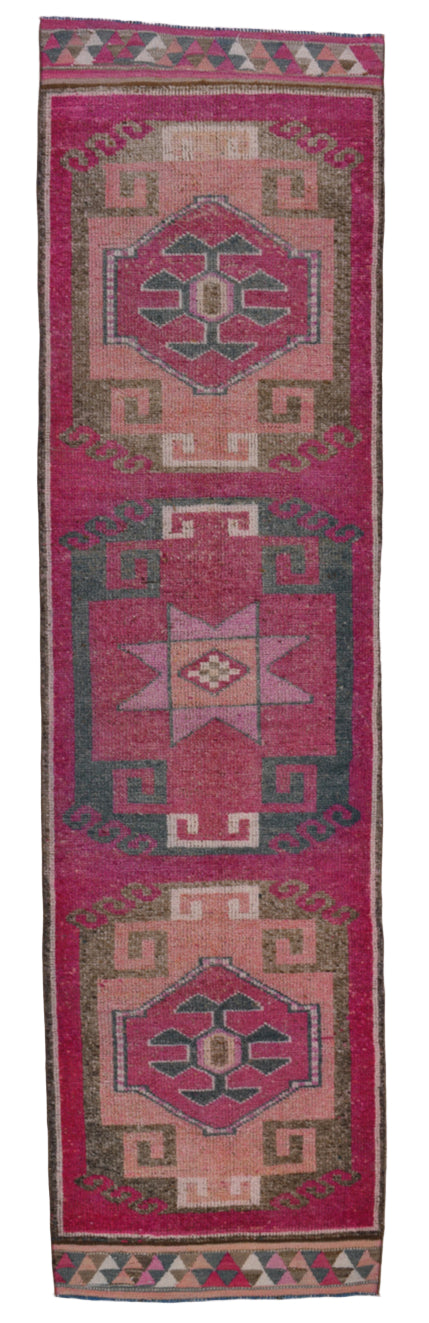 Traditional patterned rug with geometric designs on a pink background