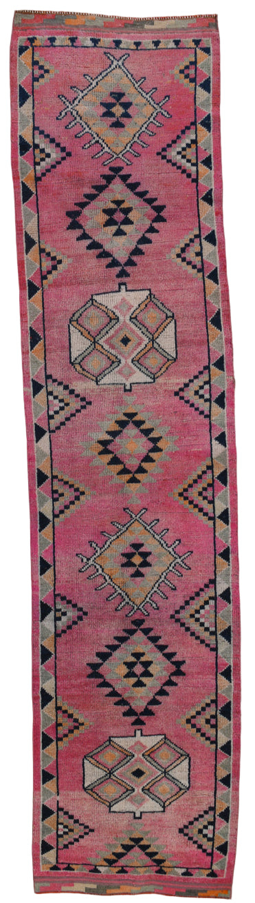 Pink rug with geometric patterns on a white background