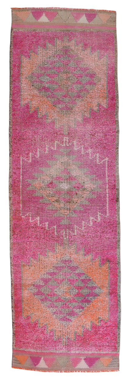 Pink woven textile with geometric patterns on a white background