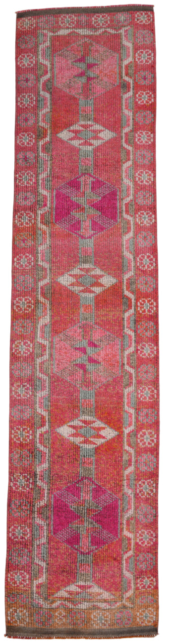 Long, narrow woven rug with geometric patterns on a plain background