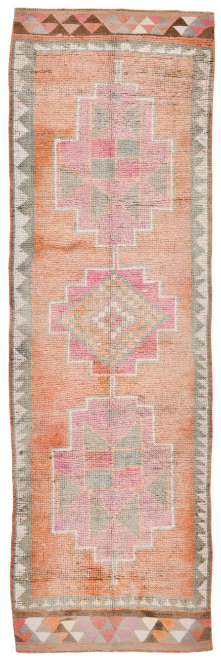 Long rectangular rug with geometric pattern on a plain background
