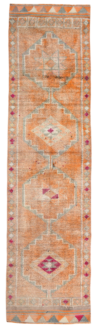 Decorative rug with geometric pattern in orange and pink on a white background