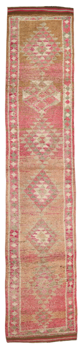 Long, narrow rug with geometric patterns in red and beige on a plain background
