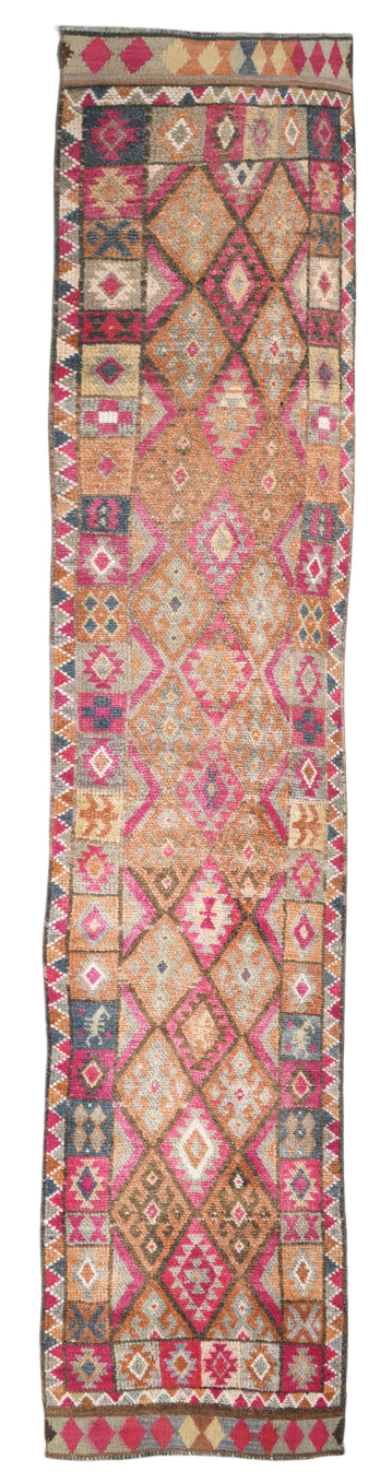 Long, narrow kilim rug with geometric pattern on a plain background