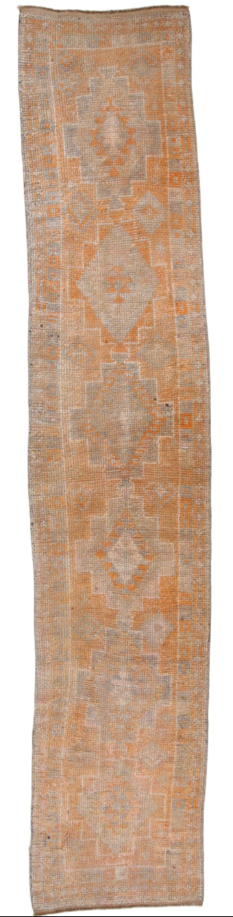 Long rectangular rug with geometric pattern on a white background