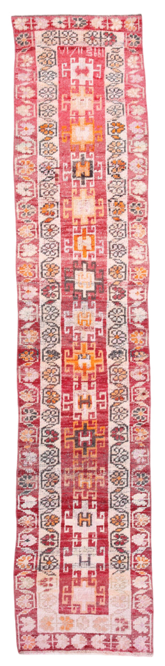 Long, narrow rug with geometric pattern on a plain background