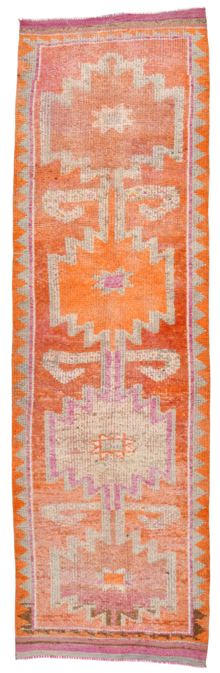 Woven textile with geometric pattern on a pink background