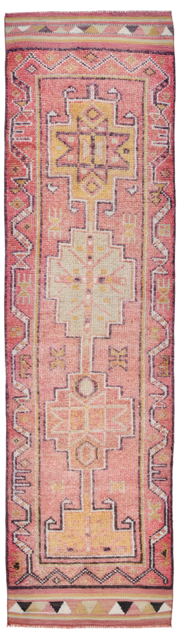 Traditional patterned rug with geometric design on a pink background