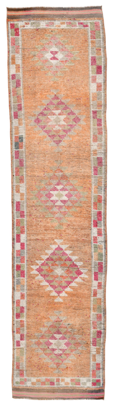 Long rectangular rug with geometric pattern on a plain background