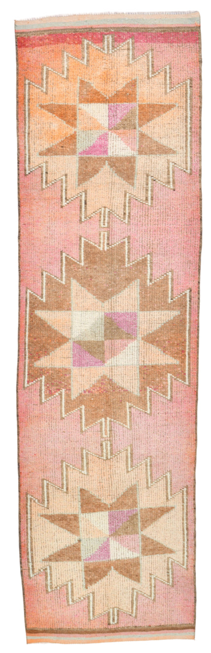 Woven textile with geometric pattern on a pink background