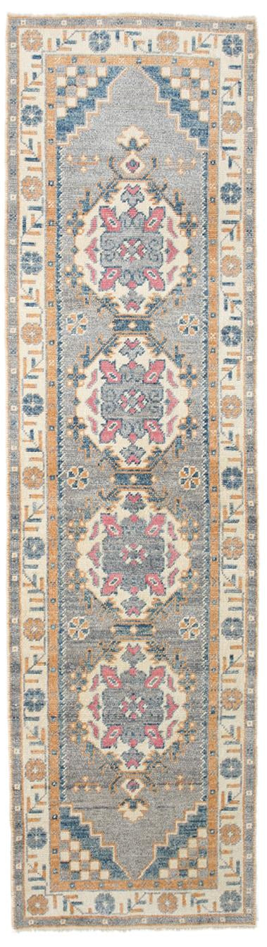 Decorative rug with intricate patterns in blue, beige, and pink on a white background