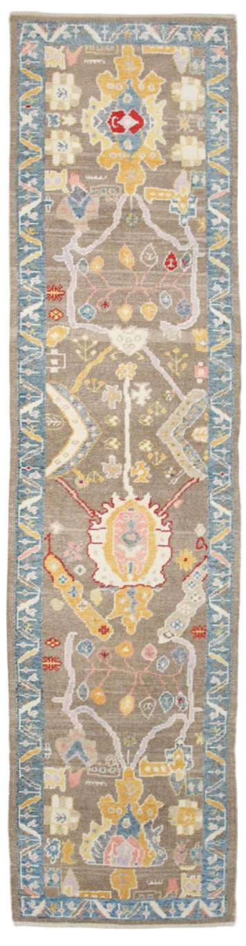 Long rectangular rug with intricate patterns and colors on a plain background