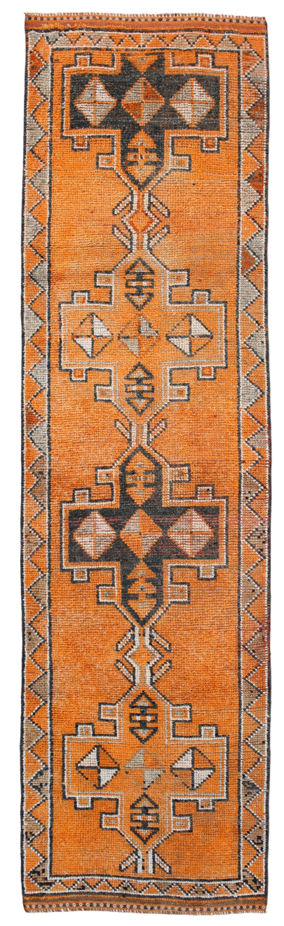 Traditional patterned rug with geometric design on an orange background