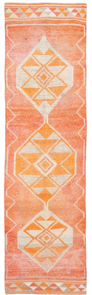 Geometric patterned rug with orange and white colors on a plain background