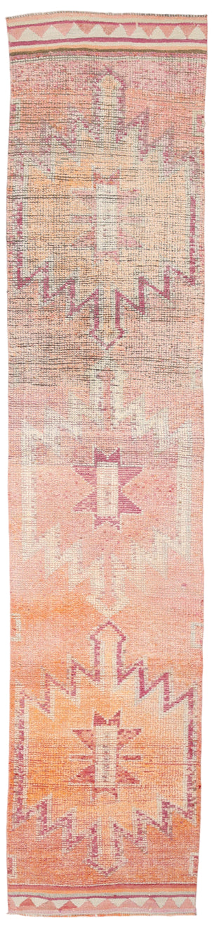 Long, narrow rug with a geometric pattern on a plain background