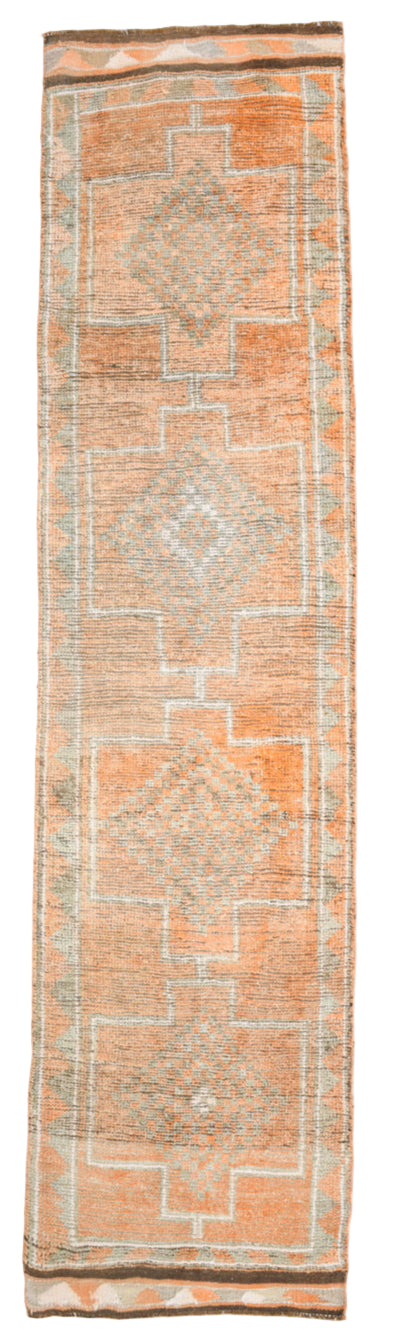 Long rectangular rug with geometric pattern on a plain background