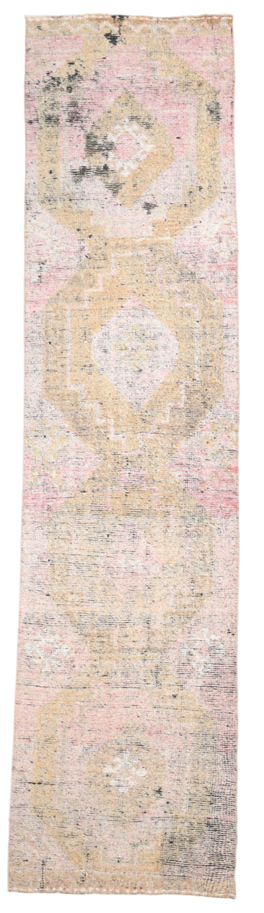 Long, narrow rug with a pattern in pastel colors on a plain background
