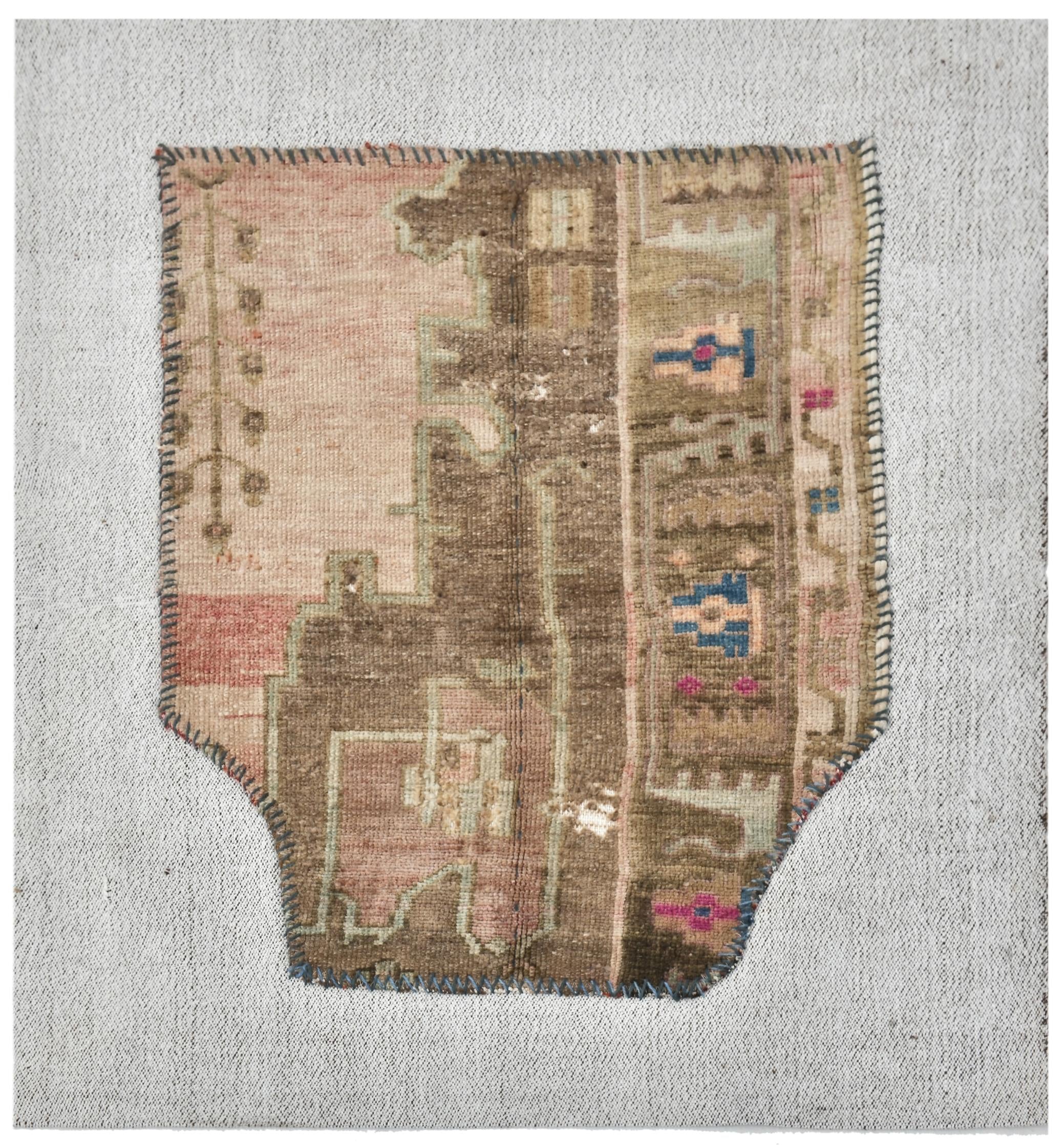 Vintage rug with intricate patterns on a textured surface