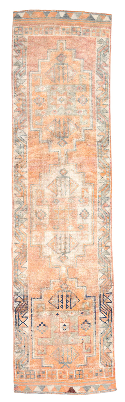 Long narrow rug with geometric pattern on a plain background