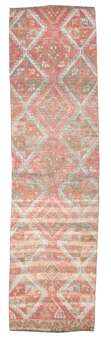 Long rectangular rug with geometric pattern in shades of pink and gray