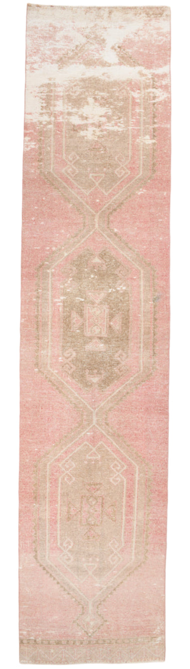 Long narrow rug with geometric pattern on a pink background