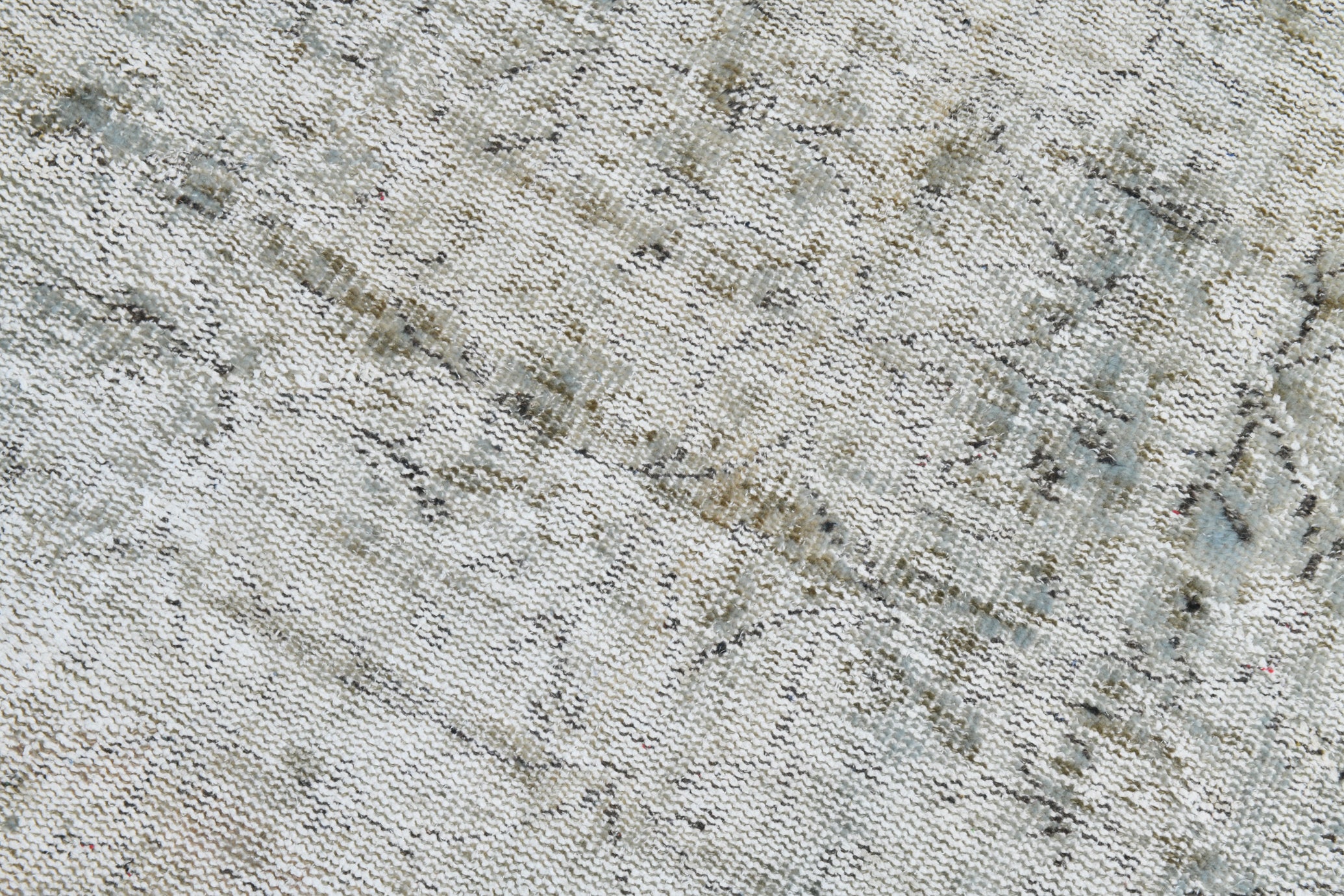 Close-up of a textured fabric with a diamond pattern in neutral colors.