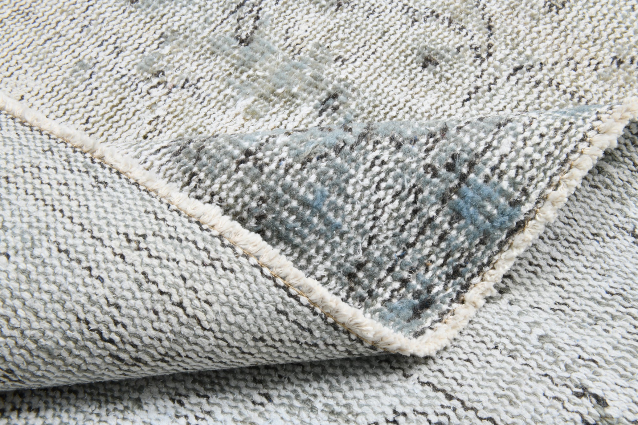 Close-up of a textured gray rug with a subtle pattern