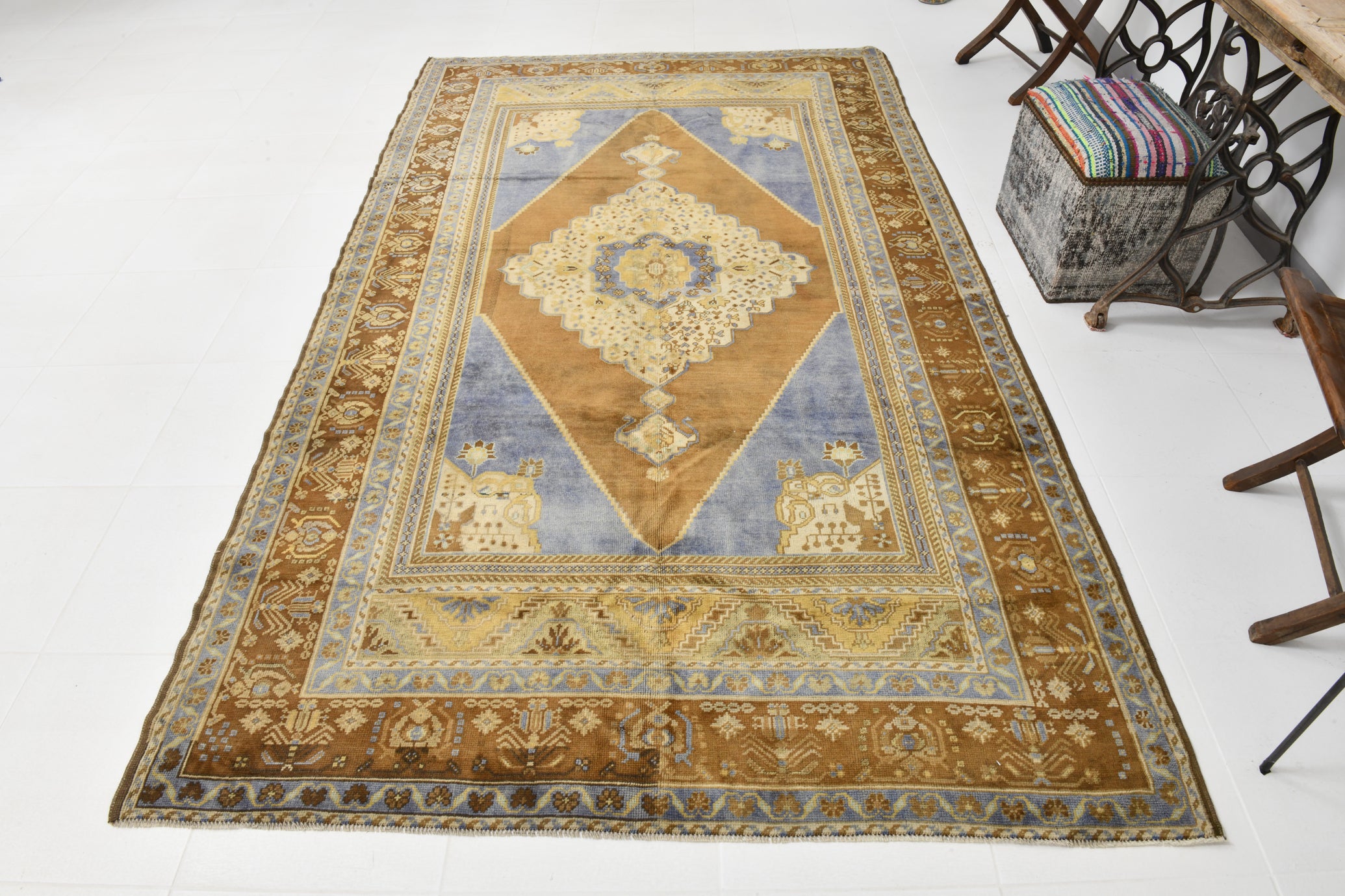 Traditional Persian or Turkish medallion carpet featuring central brown diamond motif on blue field with intricate cream floral patterns, multiple decorative borders, and classic Oriental rug design - vintage handwoven textile