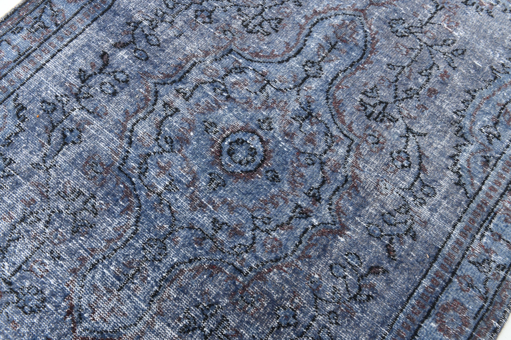 Close-up of a blue patterned rug with intricate designs.