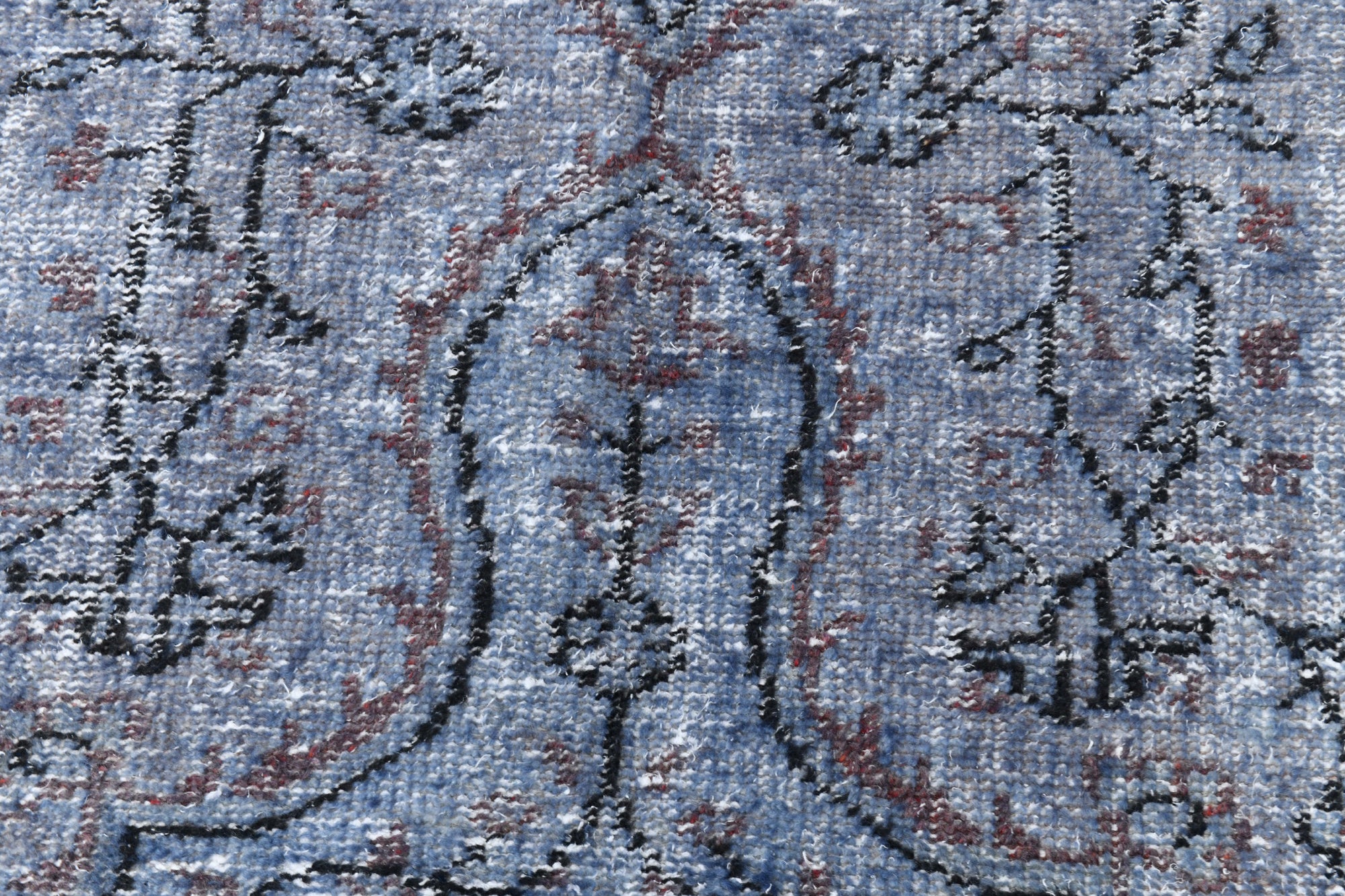 Close-up of a patterned rug with blue and brown colors