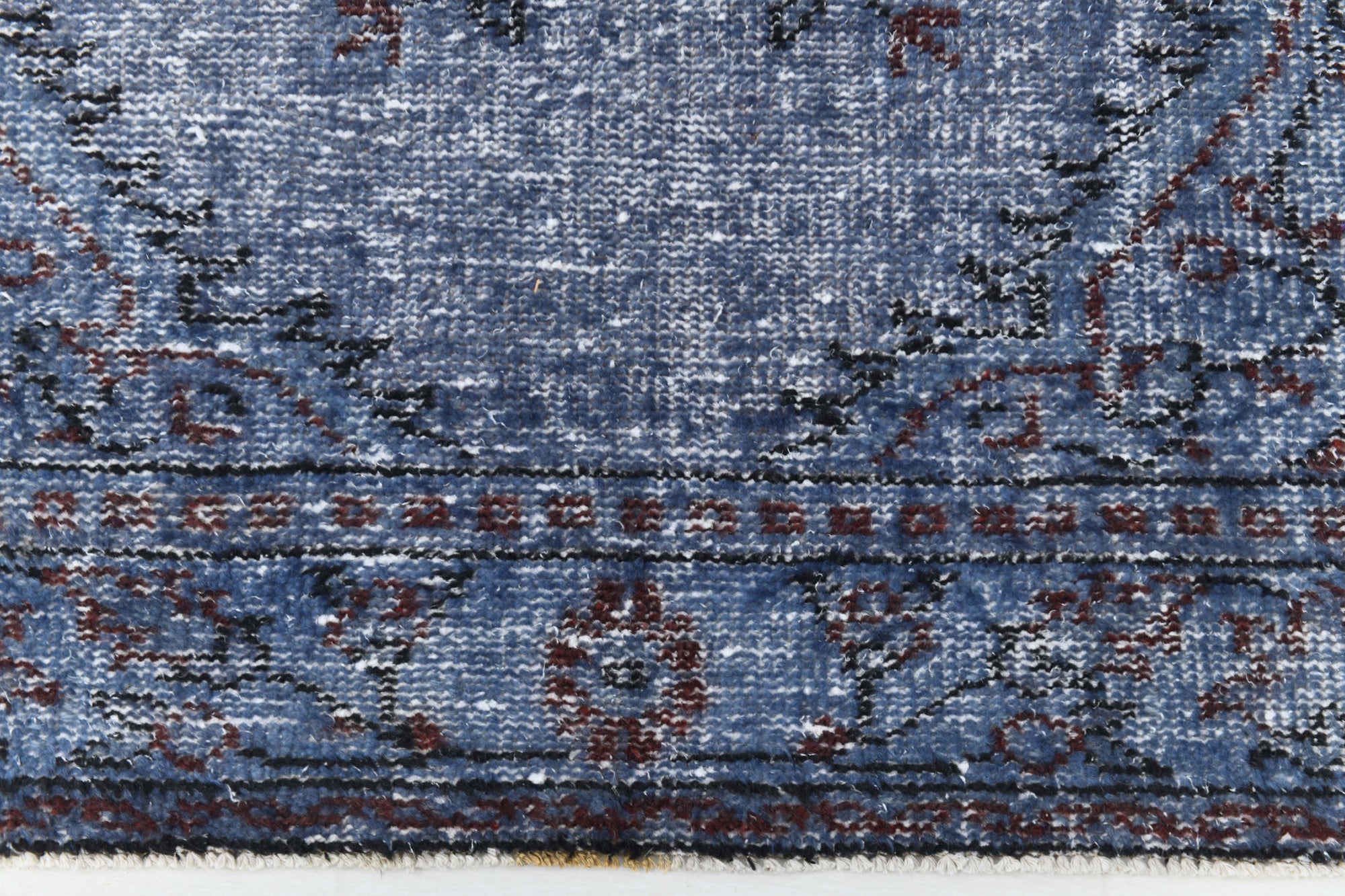 Close-up of a blue patterned rug with intricate designs.