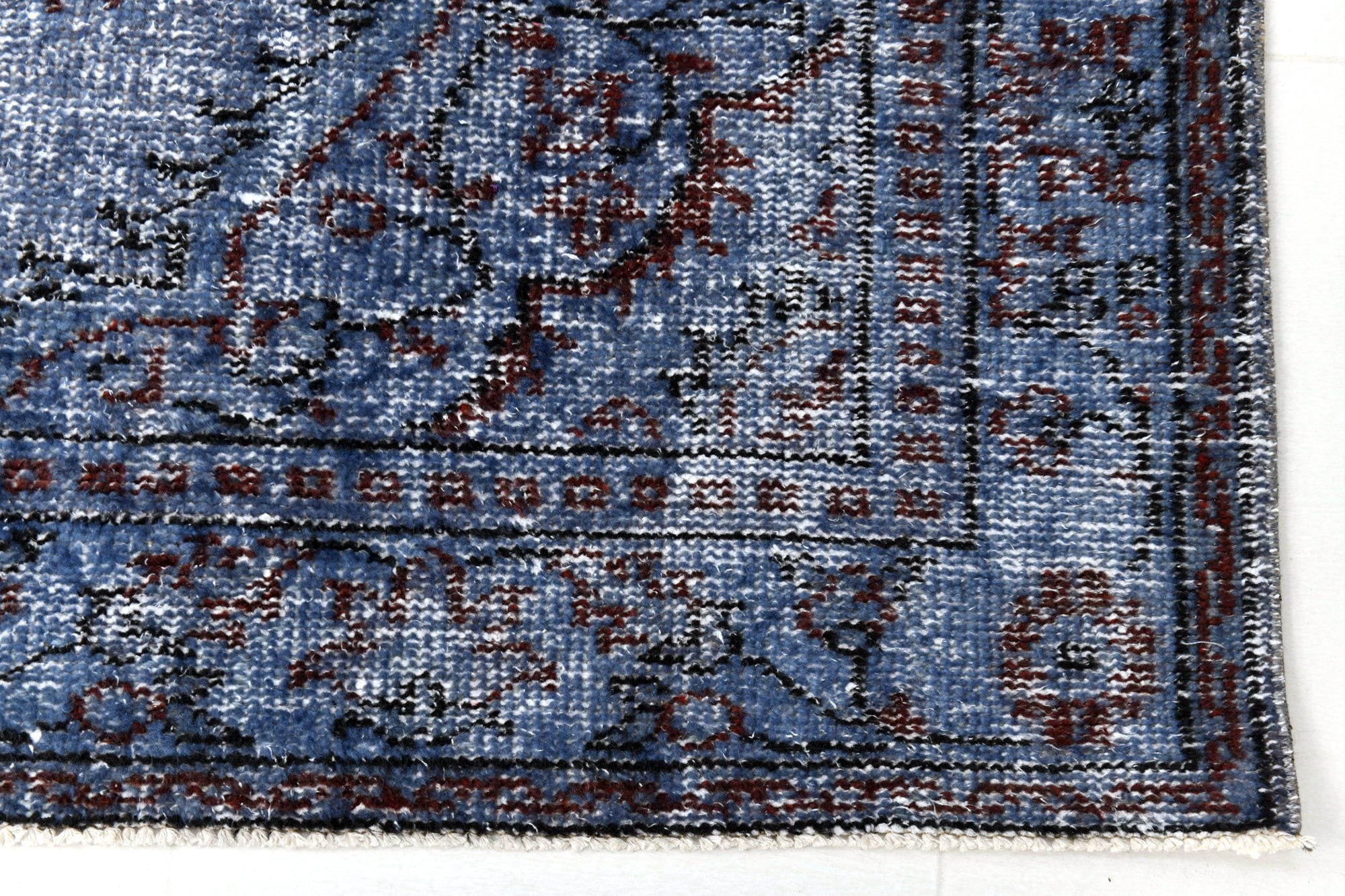 Close-up of a blue patterned rug with intricate designs.