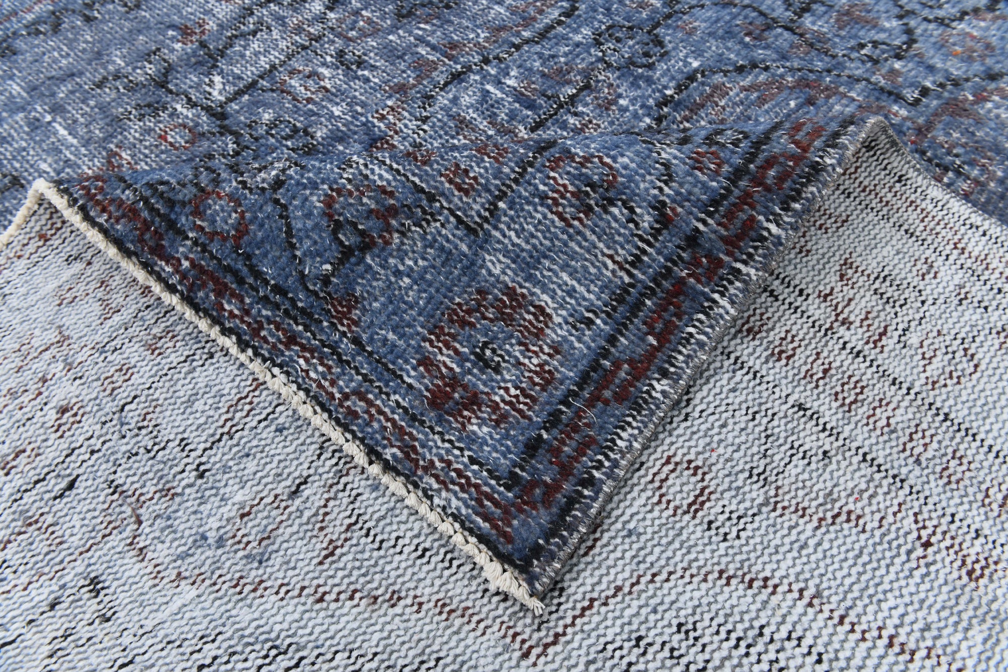 Close-up of a textured blue and gray rug corner