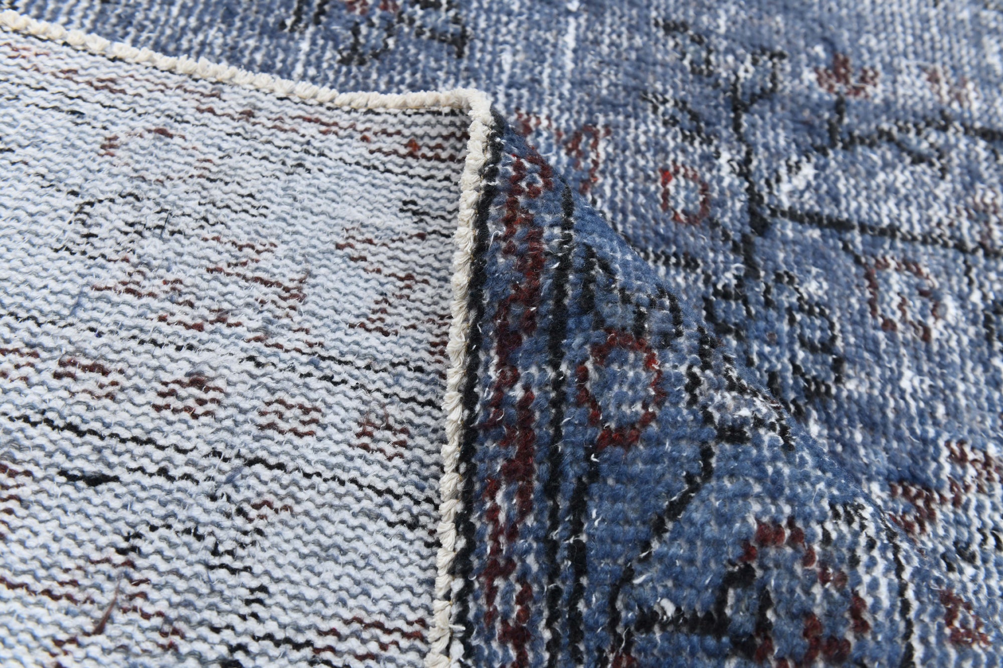 Close-up of a textured blue and gray rug corner